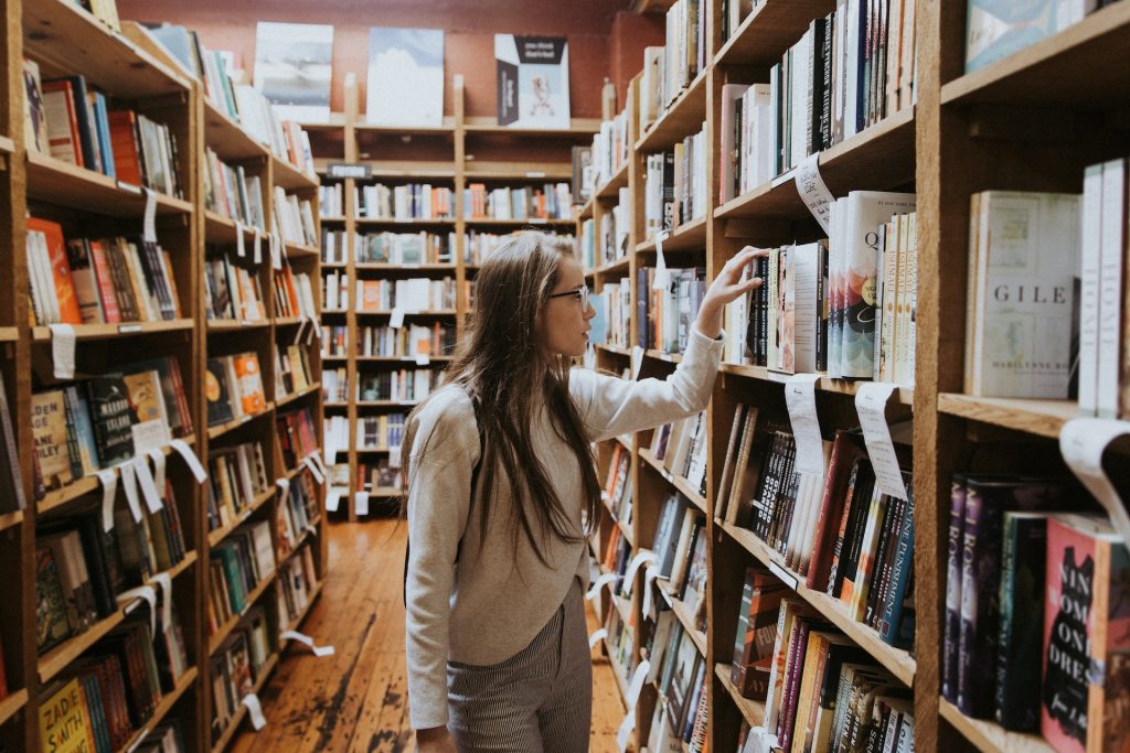 A scholar looking for a book in a library