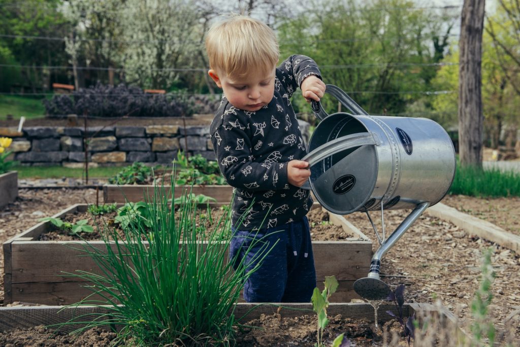 A kid watering the garden