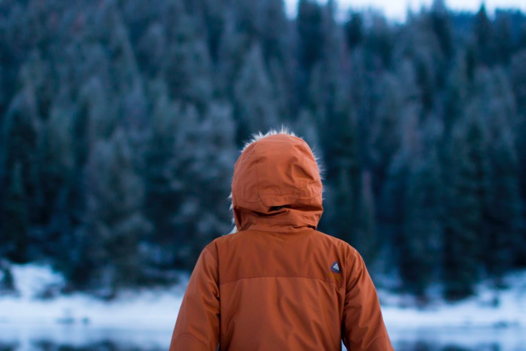 A person wearing a heavy raincoat in winter