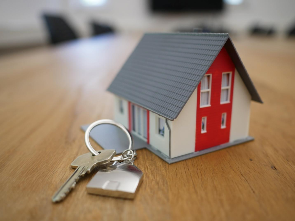 A key and house signifying real estate