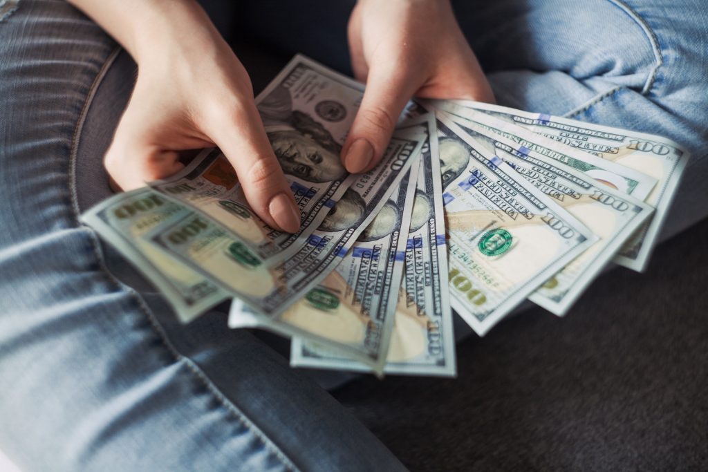 A person holding a bundle of dollars